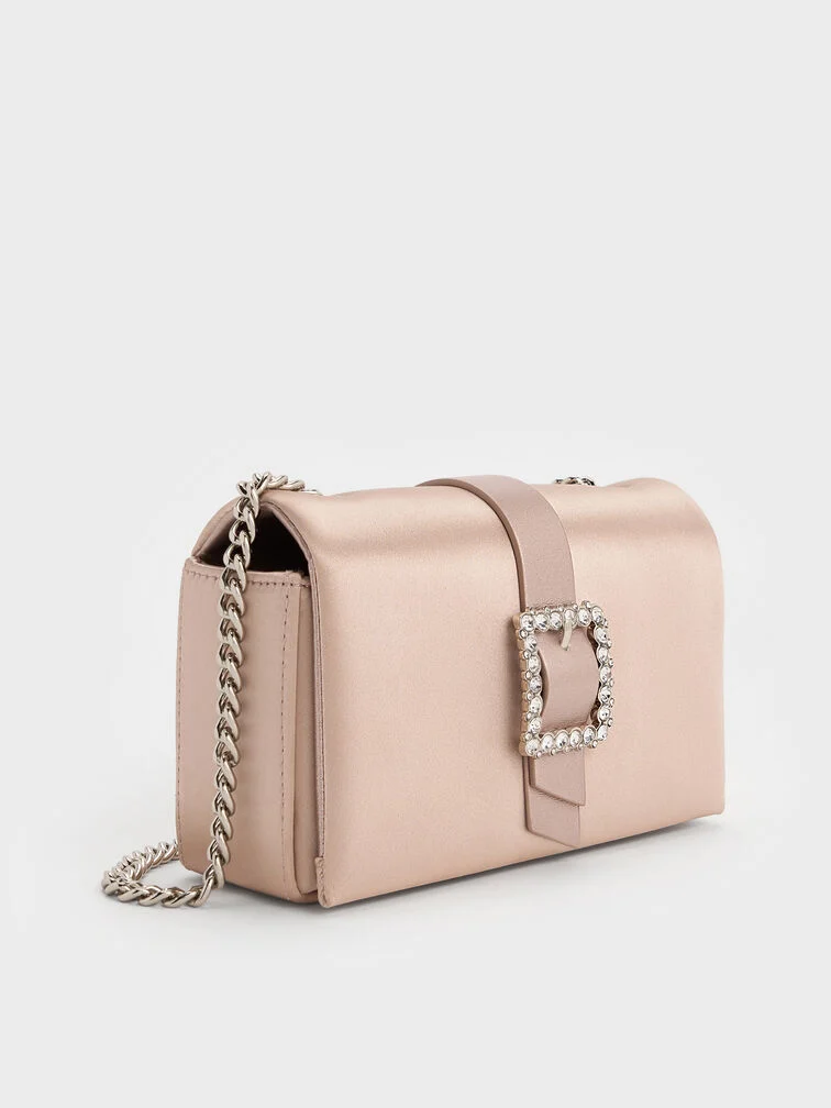 Satin clutch in blush with a crystal buckle, ideal for formal weddings or evening celebrations.