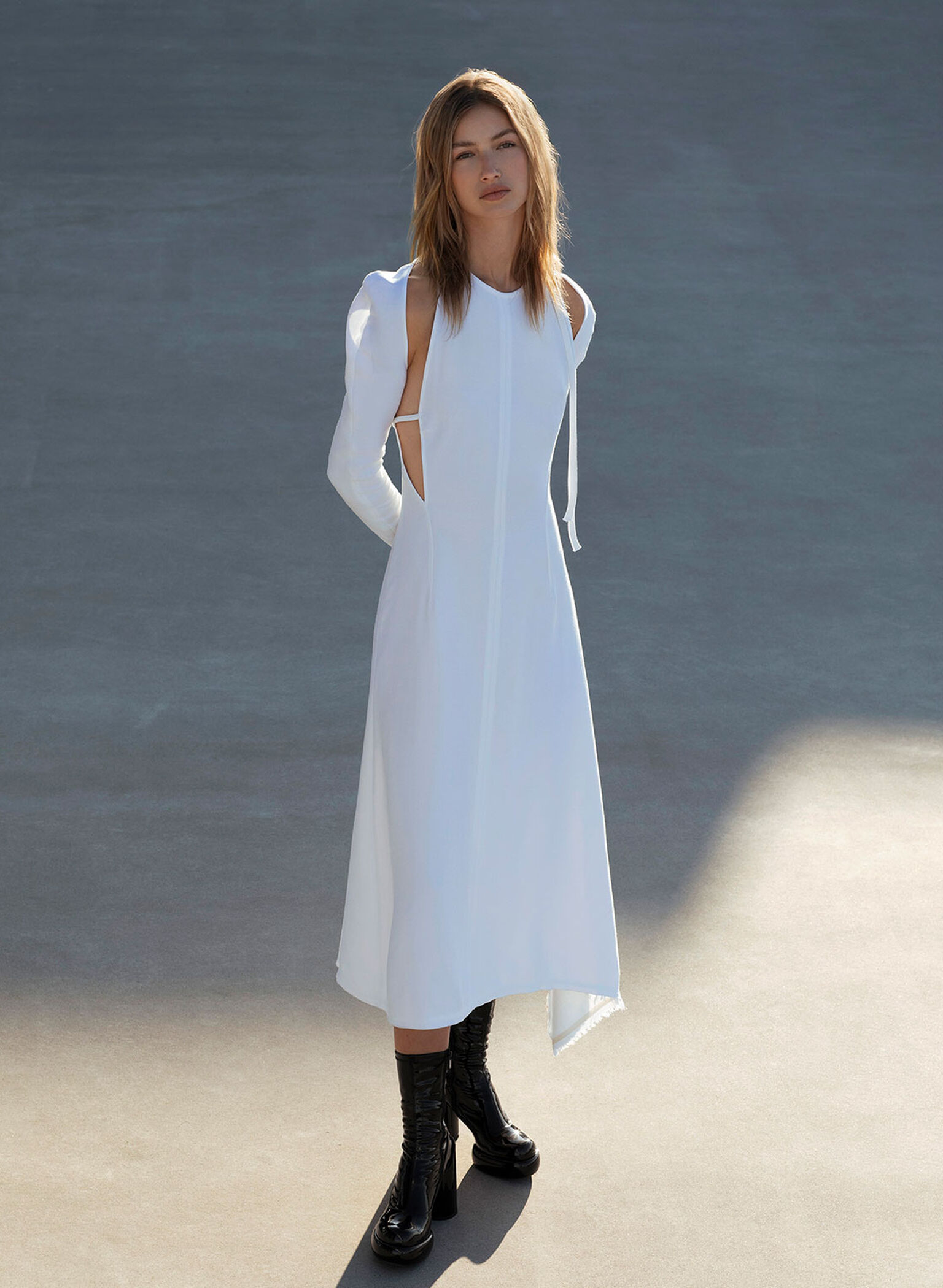Platform ankle boots elevate a cut-out white flowy dress.