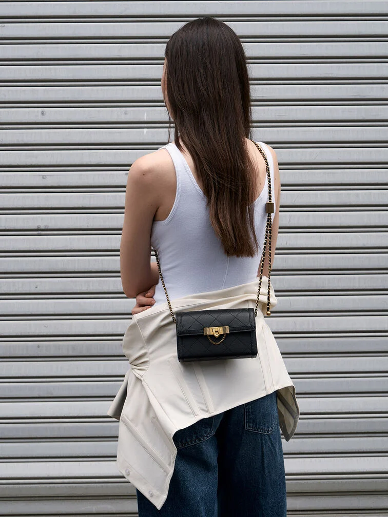 Clutch worn crossbody with a chain strap, illustrating a hands-free option for added versatility and ease of movement. 