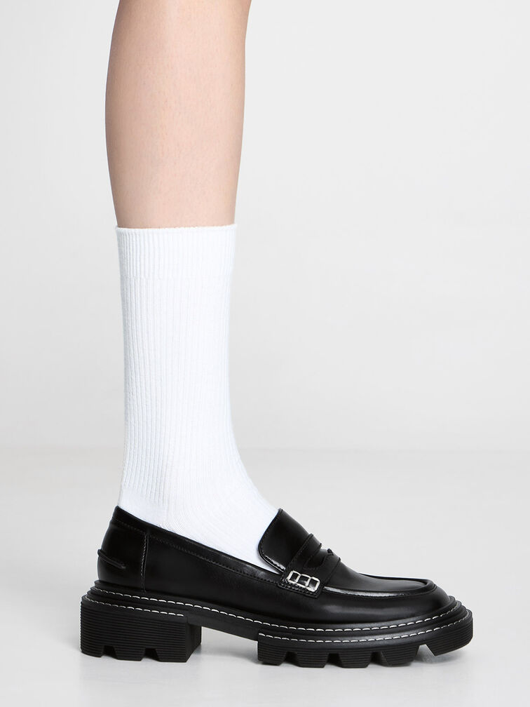 Chunky lug-sole penny loafers paired with ribbed crew socks.