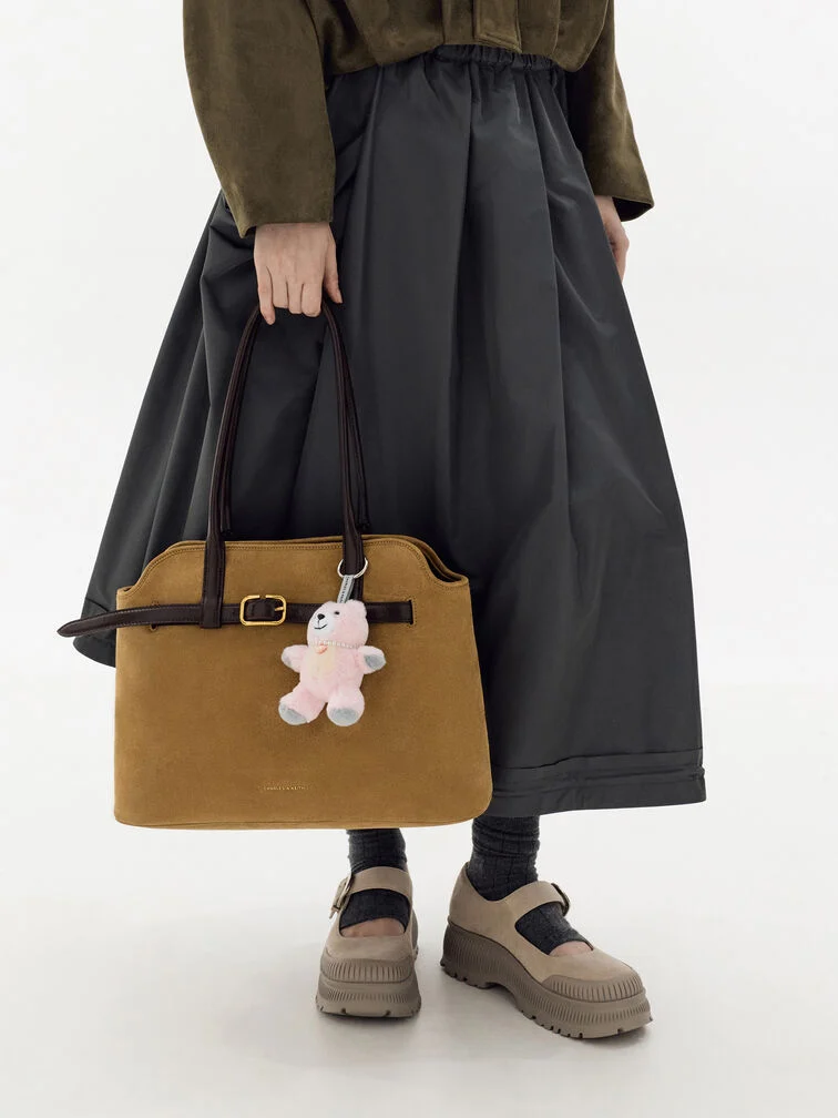 The pink plush bear charm softens the look of the Victoria tote.