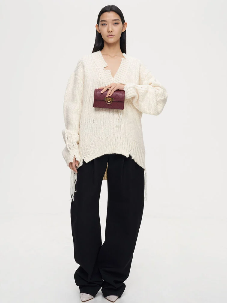 Clutch held from the top with fingers curled over the front, showing a relaxed yet elegant grip for formal occasions. 