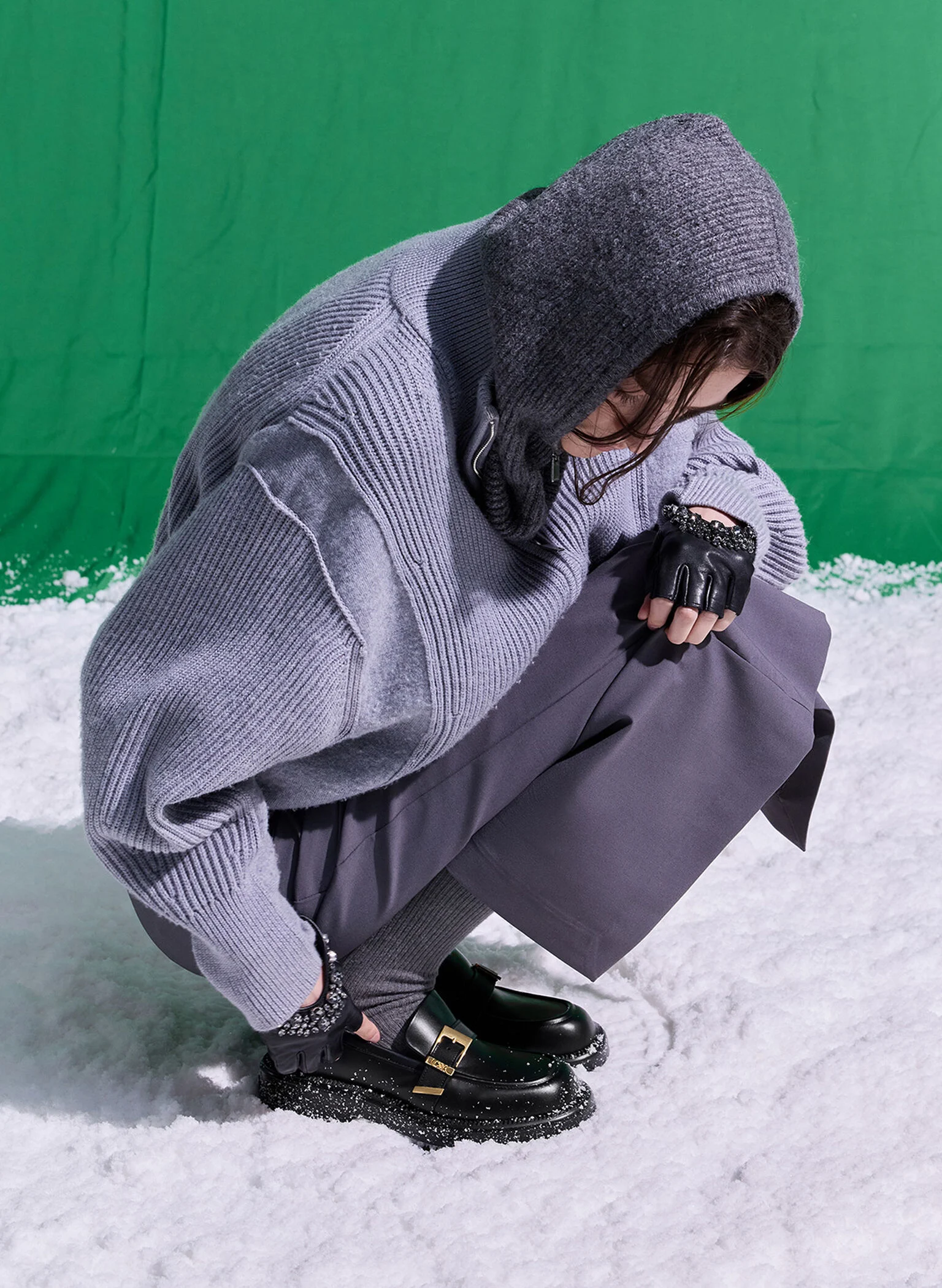 A monochromatic grey outfit featuring purple-grey socks and black buckled-strap loafers.