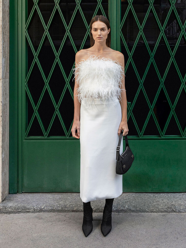 Sleek pointed-toe ankle boots paired with a feathery top and matching white skirt.