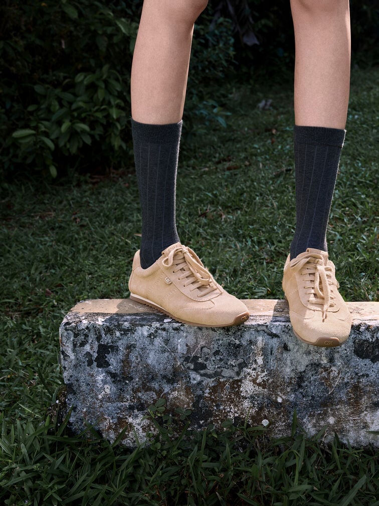 Wear suede low-profile sneakers with black calf socks to create a preppy-cool aesthetic. 