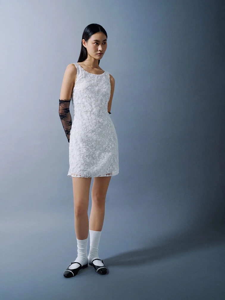 A woman wearing cap-toe flat mules, styled with classic white crew socks.